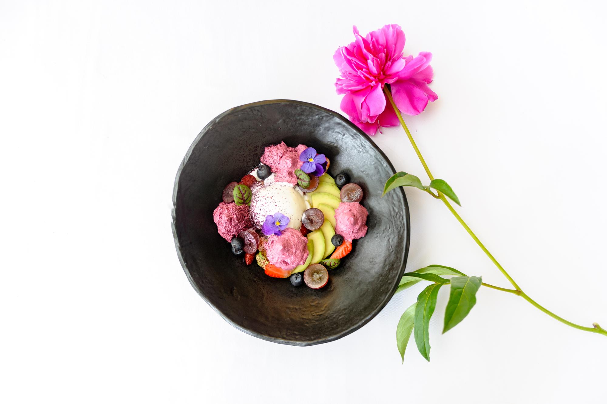 Chef arranging edible flowers on plate